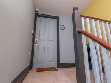 A hallway with a door and stairs at Apartment Blue in Whitby
