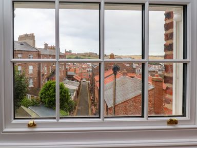 A view of rooftops and streets from a window at Apartment Blue in Whitby