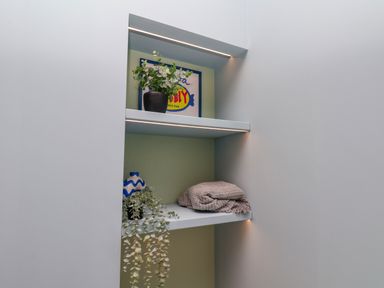 A nook with shelves containing a plant, picture, vase, and blanket at Apartment Blue in Whitby