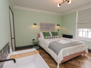 A bedroom with a bed and bathtub at Apartment Green in Whitby
