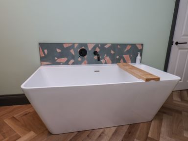 A bathtub with a wooden tray at Apartment Green in Whitby