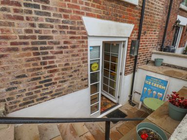 An outdoor entrance with a door and steps at Apartment Yellow in Whitby