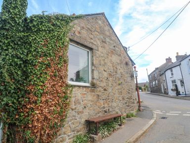 A stone wall with a bench and ivy at Chyancrowse in Gulval
