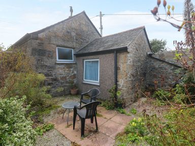 A garden area with a table and chairs near a cottage at Chyancrowse in Gulval
