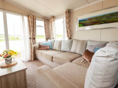 A living room with a sofa and coffee table at Roslenn in St Agnes