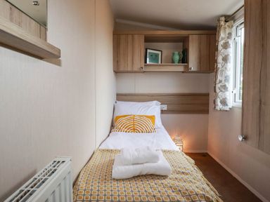 A bedroom with a bed and cabinets at Roslenn in St Agnes