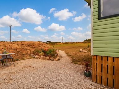A path leading to a garden with a table and chairs at Roslenn in St Agnes
