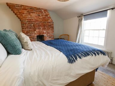 A bedroom with a brick wall and a bed at The Watch House in Weymouth