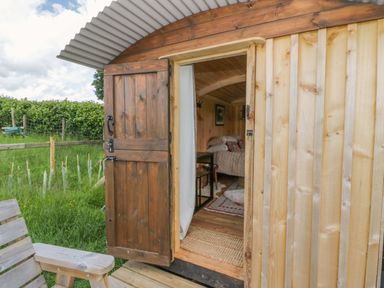 A hut entrance with furniture and grass at The Little Shepherds Hut with a View Builth Wells