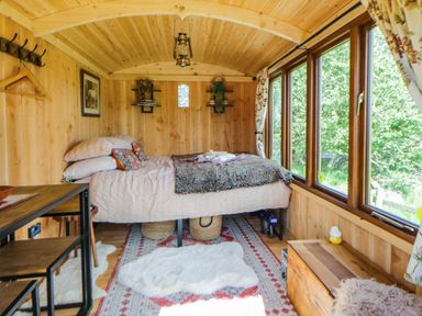 A bedroom with a bed and table at The Little Shepherds Hut with a View Builth Wells