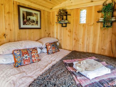 A bedroom with a bed and shelves at The Little Shepherds Hut with a View Builth Wells