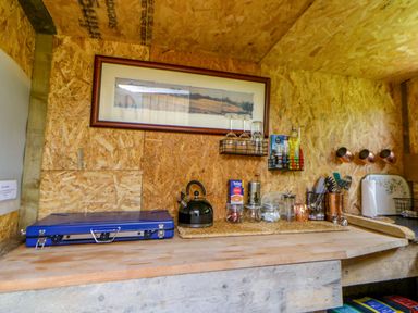 A kitchen with a stove and kettle at The Little Shepherds Hut with a View Builth Wells