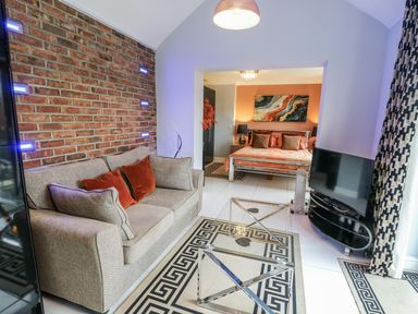 A living room with a sofa and television at Smithy Cottage in Cemaes Bay