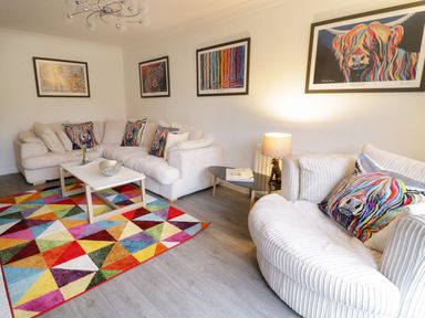 A living room with a sofa and table at Gwelfor in Cemaes Bay