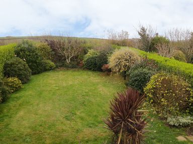 A garden with grass and plants at Gwelfor in Cemaes Bay