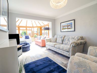 A living room with a sofa and chairs at Trefin in Cemaes Bay