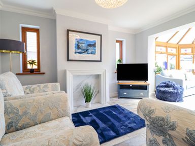 A living room with a sofa and television at Trefin in Cemaes Bay