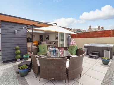 An outdoor area with a dining table and chairs at Trefin in Cemaes Bay