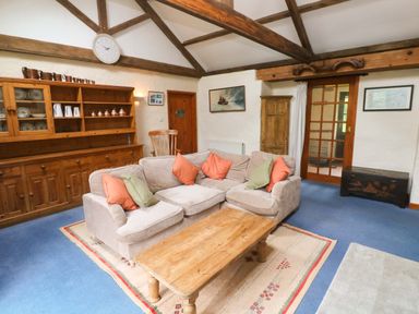 A living room with a sofa and coffee table at Swallow Cottage in Helston