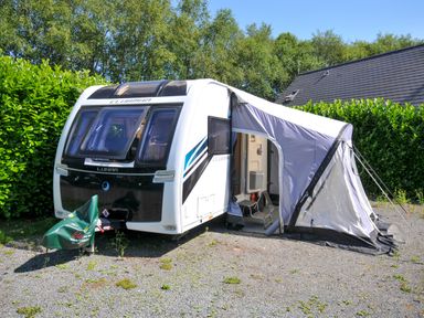 A caravan with an awning and chairs at Caravan in Dolton