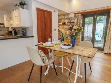 A dining room with a table set for a meal at Frome Gazey Barn in Frampton