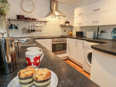 A kitchen with oven, washing machine and muffins at Frome Gazey Barn in Frampton