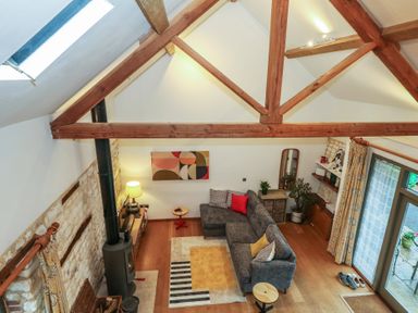 A living room with a sofa and a coffee table at Frome Gazey Barn in Frampton