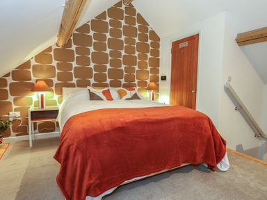 A bedroom with a bed and bedside tables at Frome Gazey Barn in Frampton