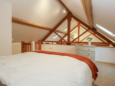A bedroom with a bed and chest of drawers at Frome Gazey Barn in Frampton