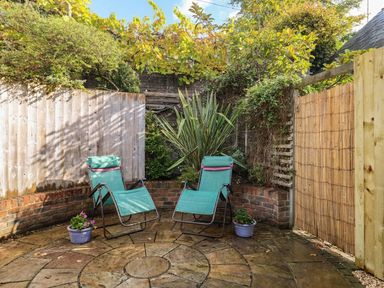 A garden with two deck chairs and flower pots at Frome Gazey Barn in Frampton
