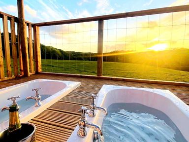 Two bathtubs on a wooden deck with a scenic view at a property