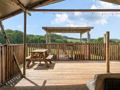 A deck with a wooden table and benches overlooking a landscape at Luxury Safari Lodge Sleeps 4/6 Deer Park Dogs Ok Zeal Monachorum near Bow