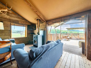 A living room with a sofa and wooden wall at Luxury Safari Lodge Sleeps 4/6 Deer Park Dogs Ok, Zeal Monachorum near Bow