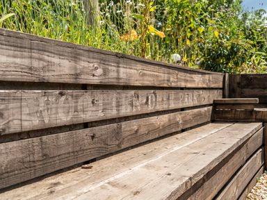 A wooden bench in a grassy area at Woolley Park
