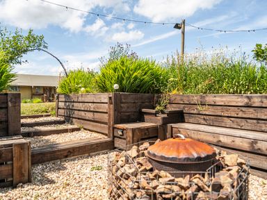 A garden with wooden planters and a fire pit at Luxury Safari Lodge Sleeps 4/6 Deer Park Dogs Ok Zeal Monachorum near Bow