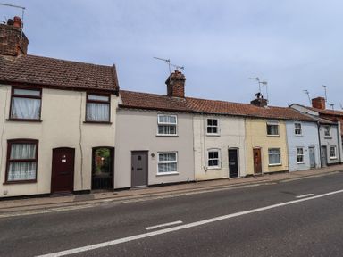 A row of houses with doors and windows on a street at Pax Cottage in 
