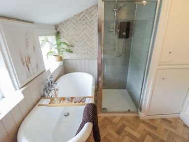A bathroom with a bathtub and shower in Pax Cottage