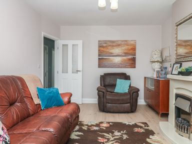 A living room with a sofa and armchair at 3 Heath Park in Brixham