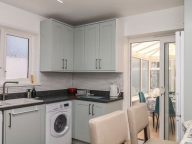 A kitchen with cabinets and appliances at 3 Heath Park in Brixham