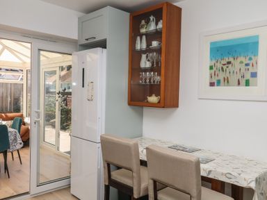 A kitchen featuring a refrigerator, table and bar stools at 3 Heath Park Brixham