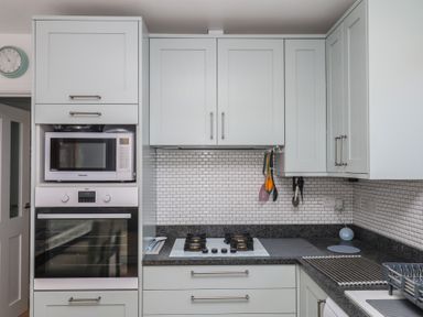 A kitchen with cabinets, microwave, oven, and stove at 3 Heath Park in Brixham