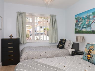 A bedroom with two beds and a window at 3 Heath Park in Brixham