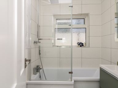 A bathroom with a bathtub and shower at 3 Heath Park, Brixham