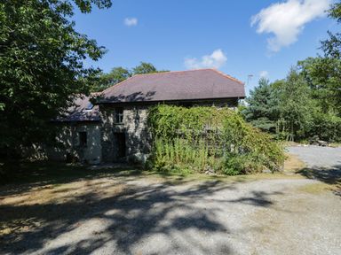 A stone building with plants around it at Yr Hen Felin Boncath