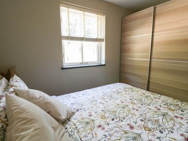 A bedroom with a bed and a window at Yr Hen Felin in Boncath