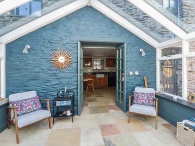 A conservatory with chairs and a table at Yr Hen Felin in Boncath