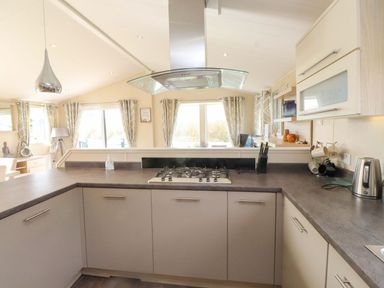 A kitchen with gas stove and sink at 56 The Stables Pwllheli