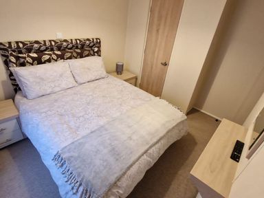 A bedroom with a bed and bedside table at 56 The Stables in Pwllheli