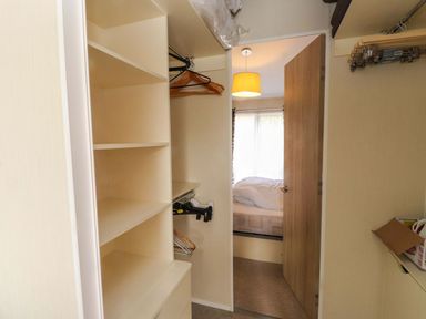 A closet with shelves and hangers in a bedroom at 56 The Stables Pwllheli