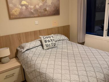 A bedroom with a bed and bedside table at The Stables in Pwllheli